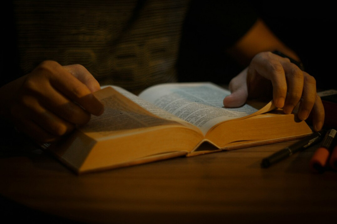 Hand writing in a notebook with a pen